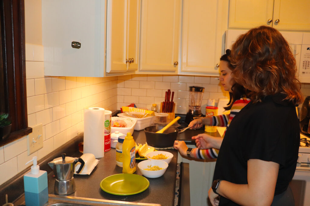 Maria Brunetta (left) and Larissa Pasquini (right) cook Brazilian hotdogs in their Madison home. This dish is commonly served at birthday parties in Brazil.