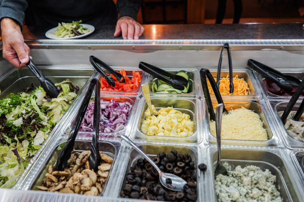 Salad bar featuring a variety of vegetables and other salad toppings.