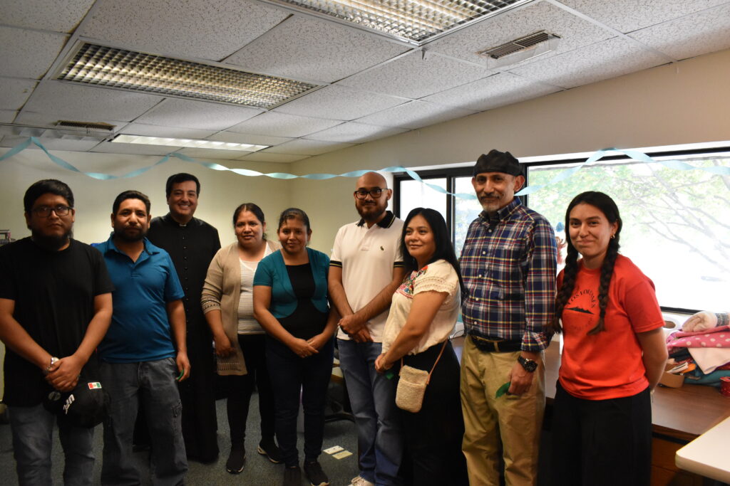 A group of workers all standing together in a building. 