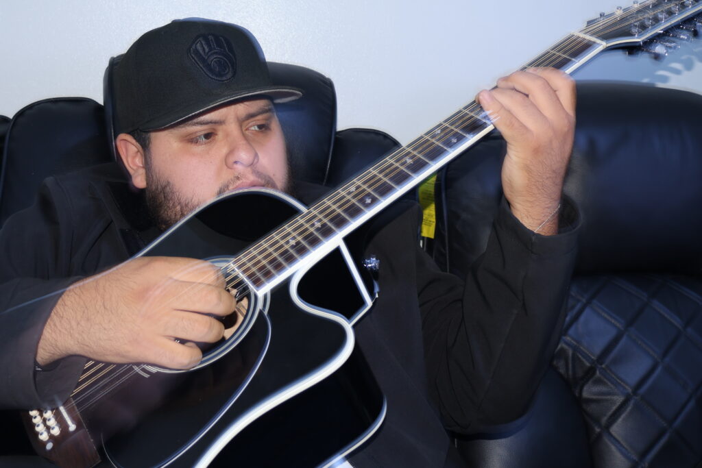 Martin Flores playing guitar, one of the guitarists of Klan 414.