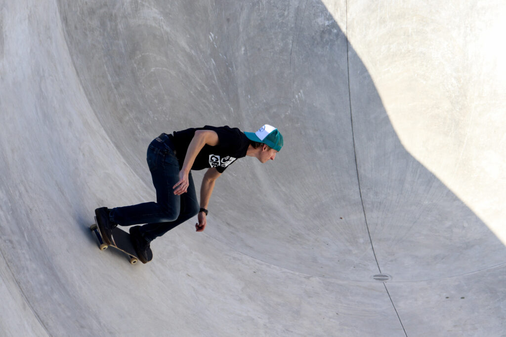 Man riding skateboard in a concrete bowl