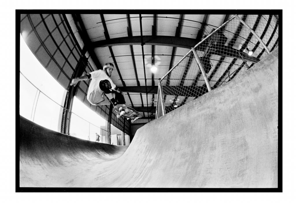 Skateboarder doing a frontside ollie in the skate park. 