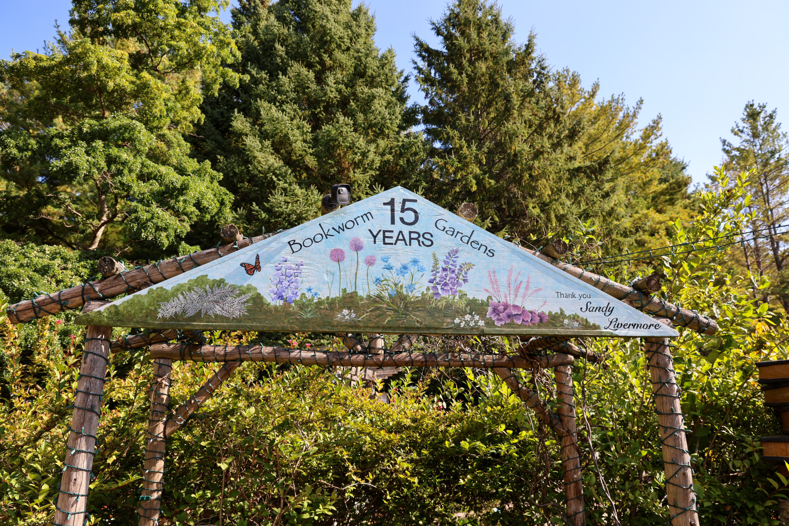 A canopy that reads, "Bookworm Gardens, 15 Years."