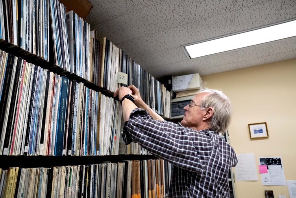 Radio broadcaster, Norman Gilliland, sifts through a vinyl record collection at WPR.