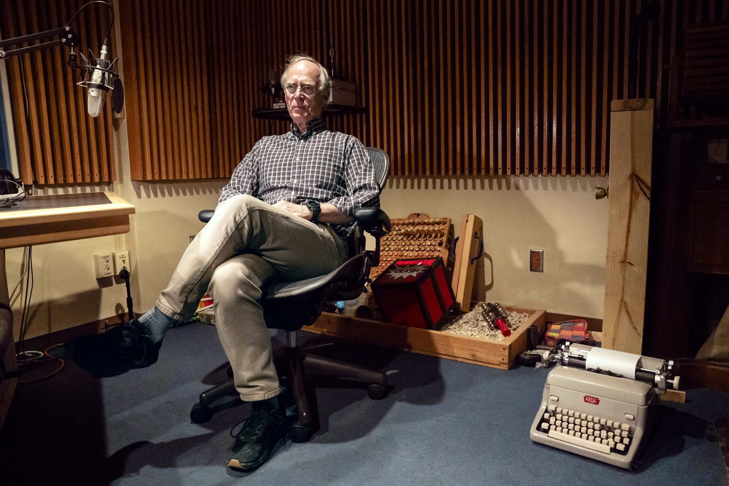 Radio broadcaster, Norman Gilliland, sits in a sound recording booth at WPR.