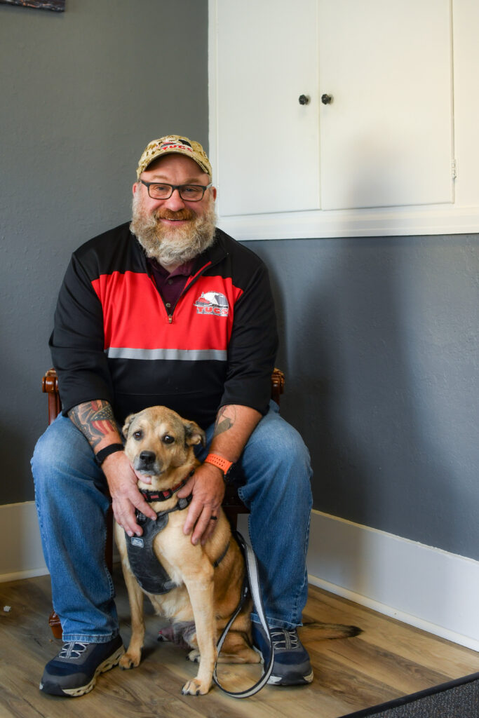 Jeff Ditzenberger smiles behind his dog.