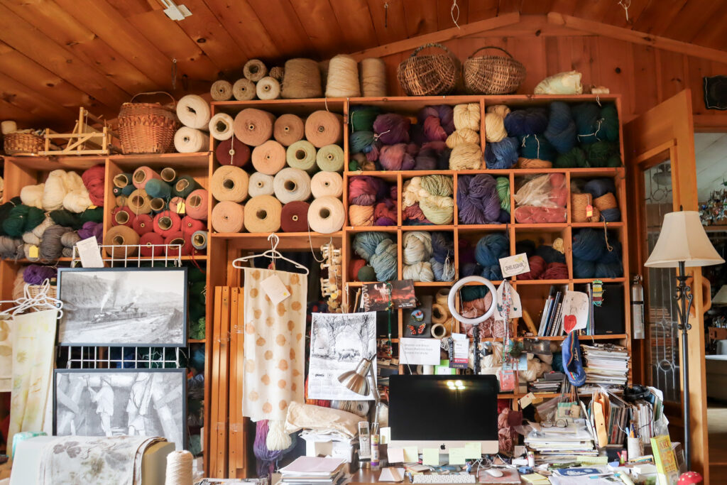 A workshop full of yarns and other weaving material.