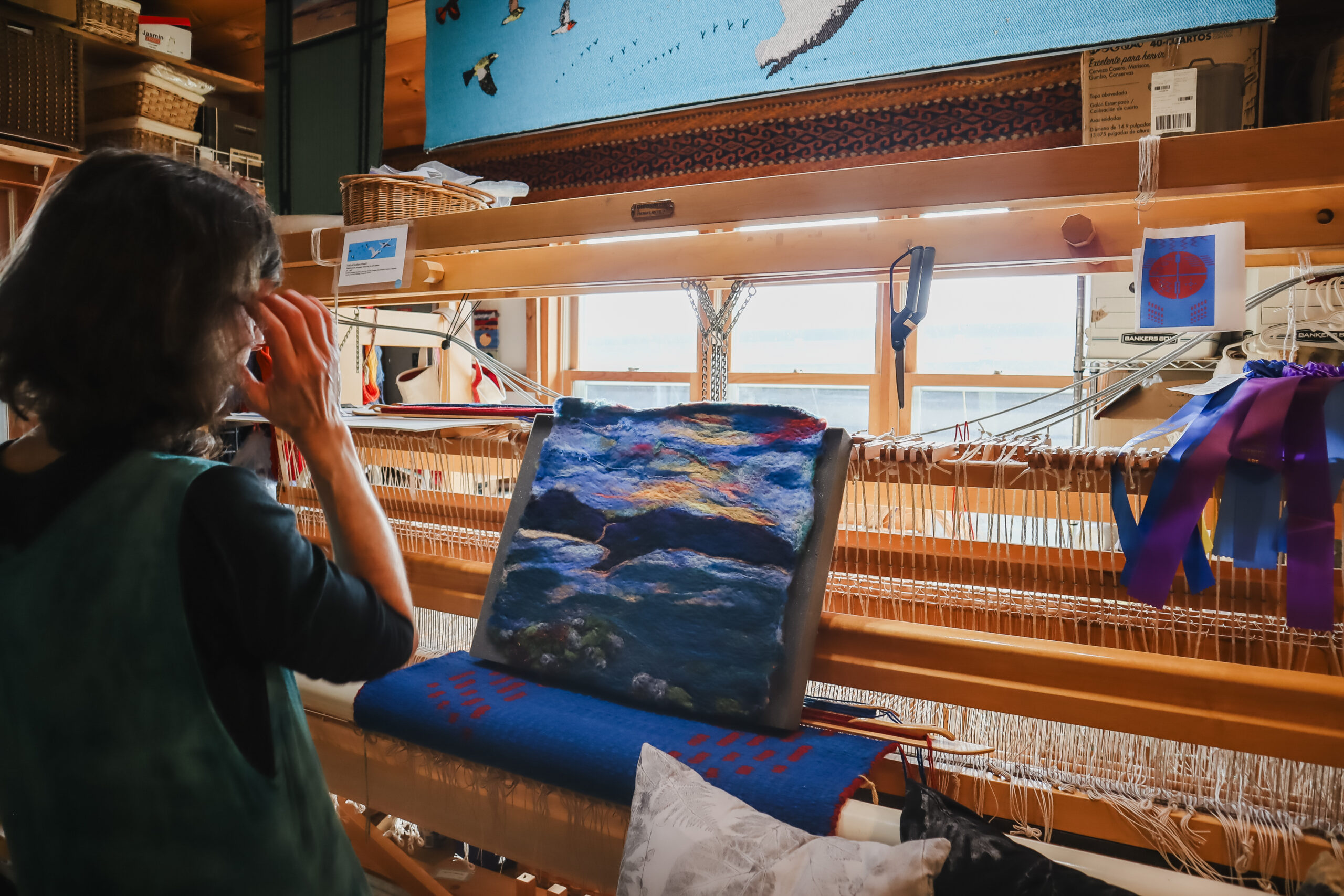 A loom with a tapestry depicting a lake landscape.