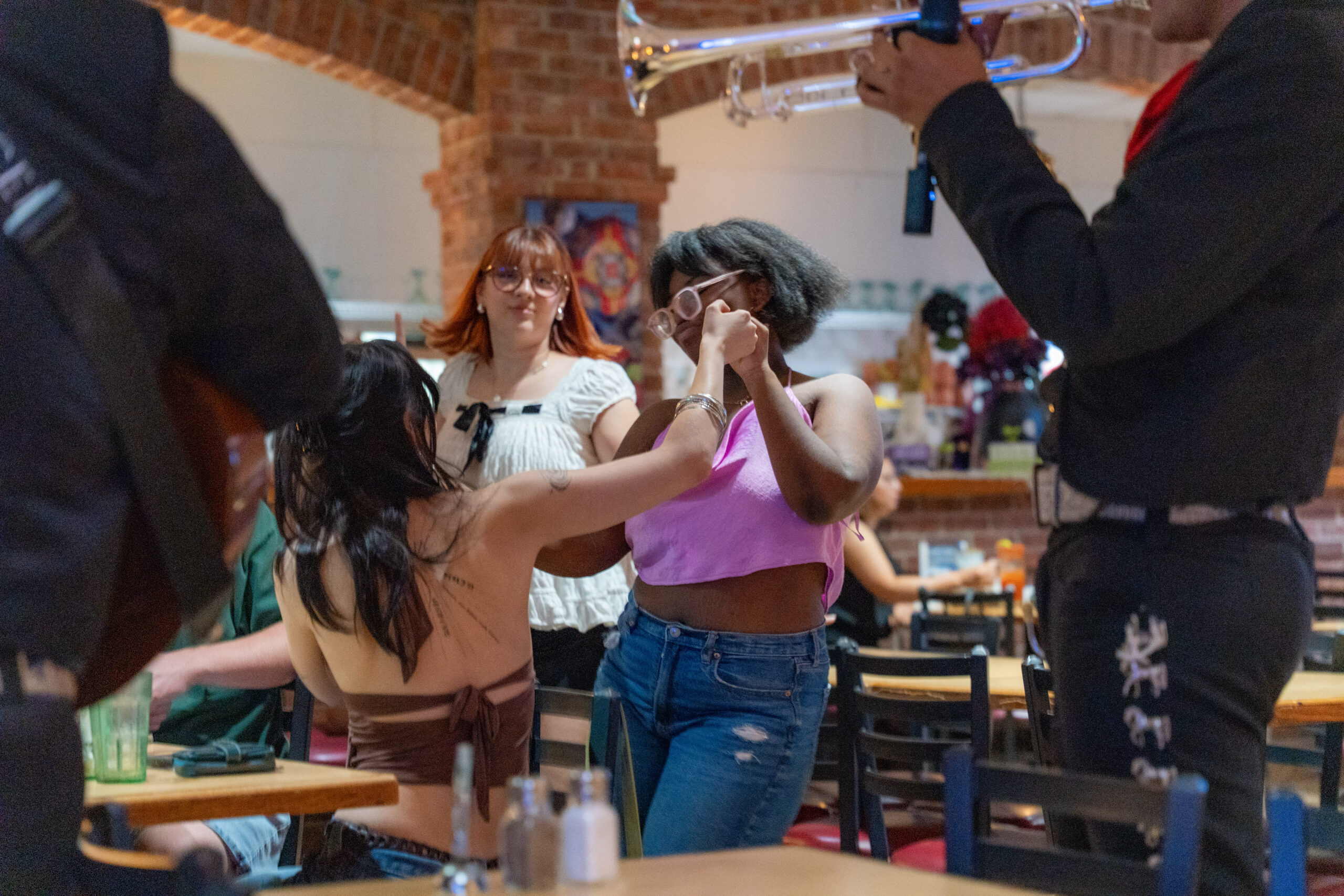Girls dancing together to the Mariachi band.