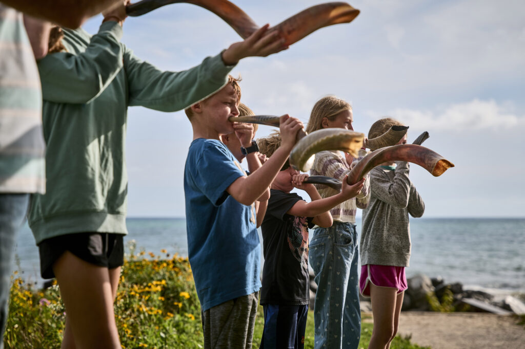 Children blowing through horns.