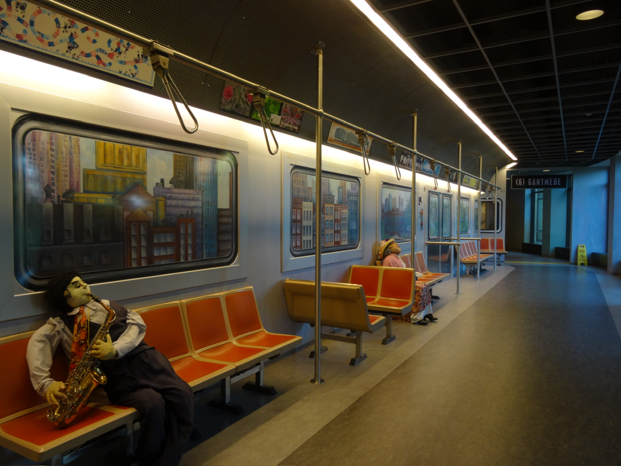Puppets sit on seats inside a subway car.