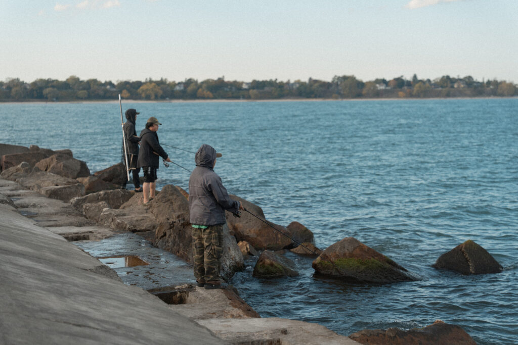 people fishing off of rocks in the lake