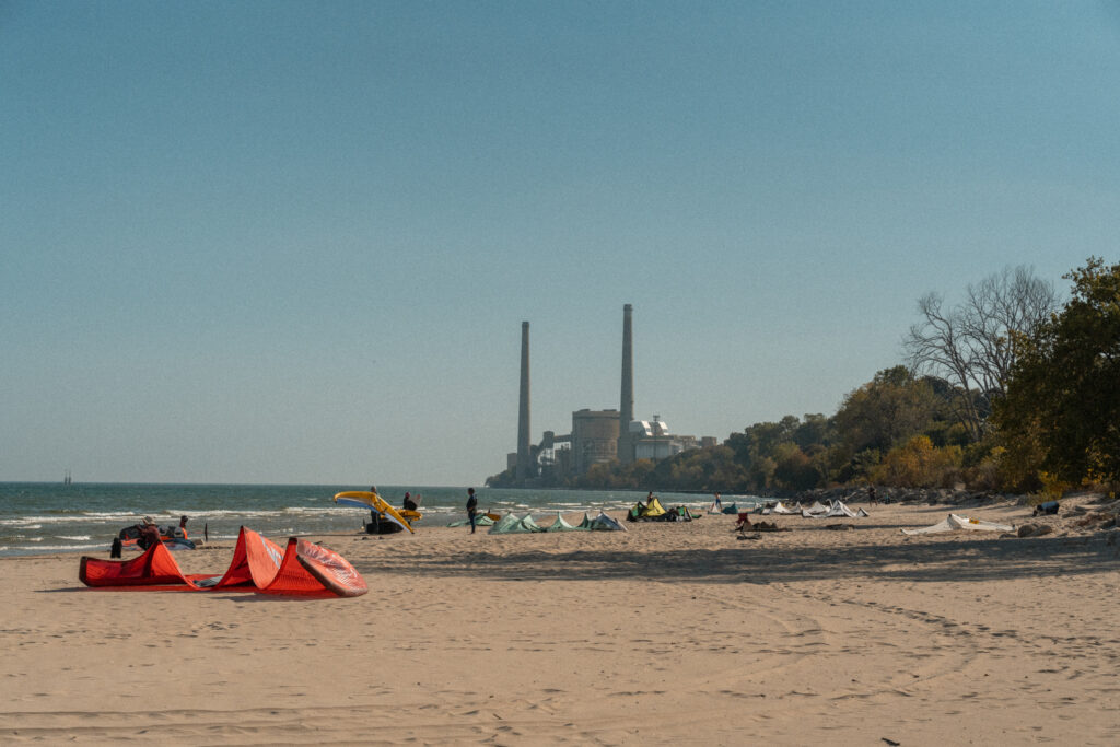 beach with people and smoke stakes in the distance