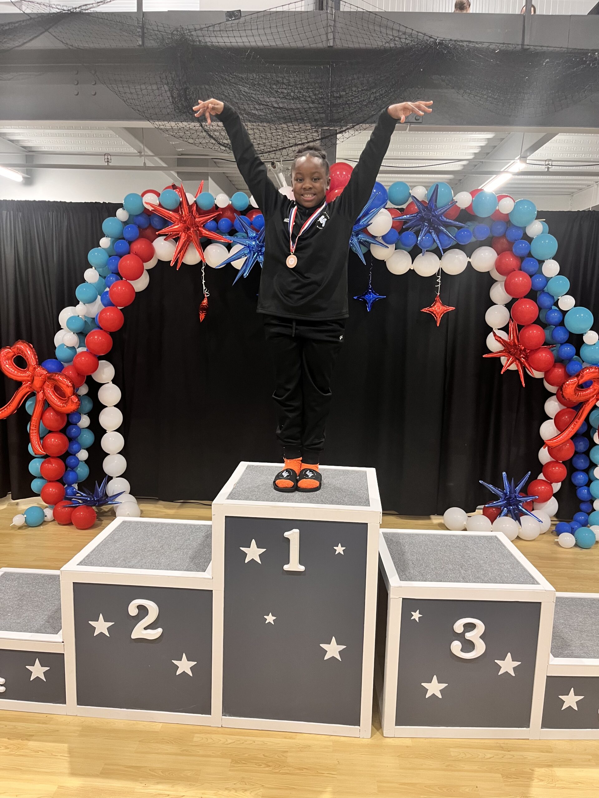 Jaedyn stands on top of a first-place podium.