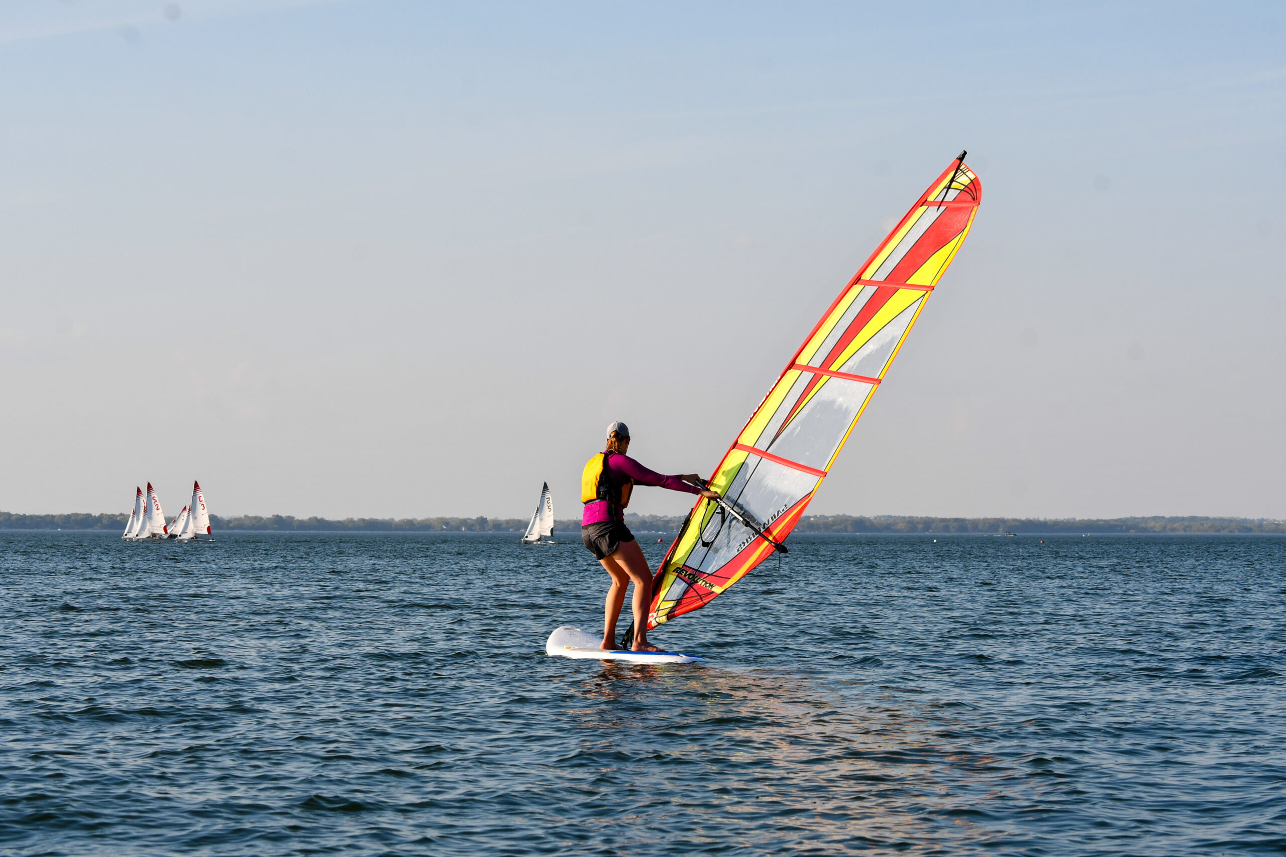 Facing out into the lake, the windsurfer catches a breeze.